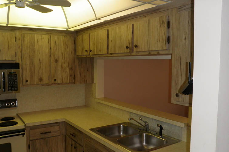 very old wooden dark colored cabinets above a sink