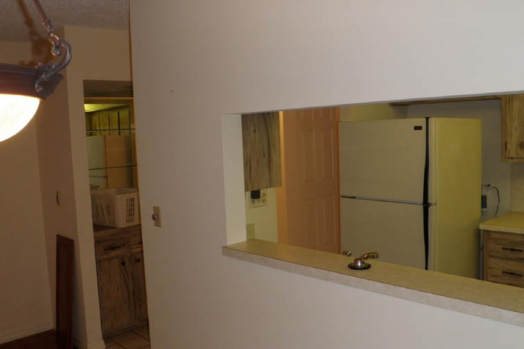 wooden cabinets with a silver sink and white dishwasher