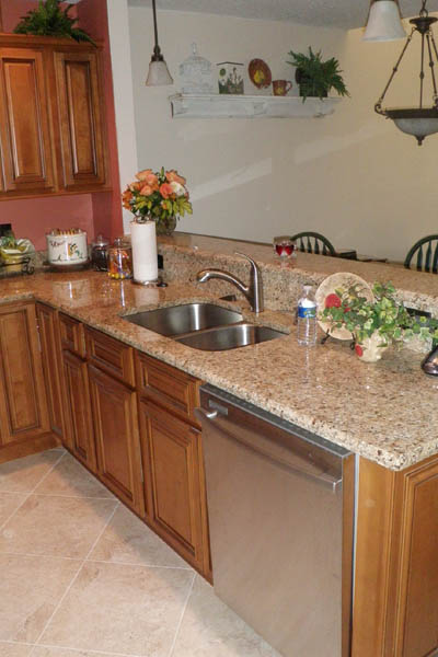 cabinets under a countertop with a brand new silver dishwasher