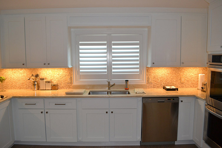 all white new and furnished kitchen with glossy countertop and new dishwasher