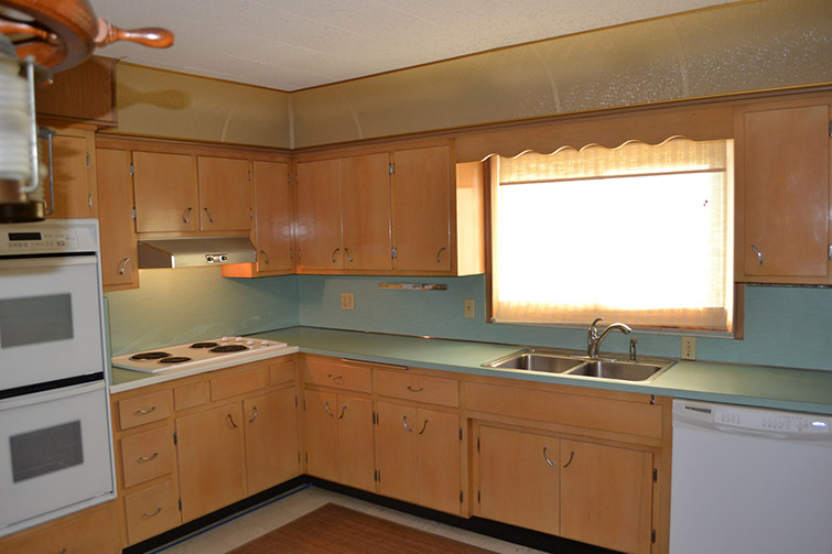 old looking blue countertop surrounded by beige cabinets